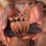 A young Himba girl holds a newly made Erembe, or the crown made of goat skin that is worn by married Himba women