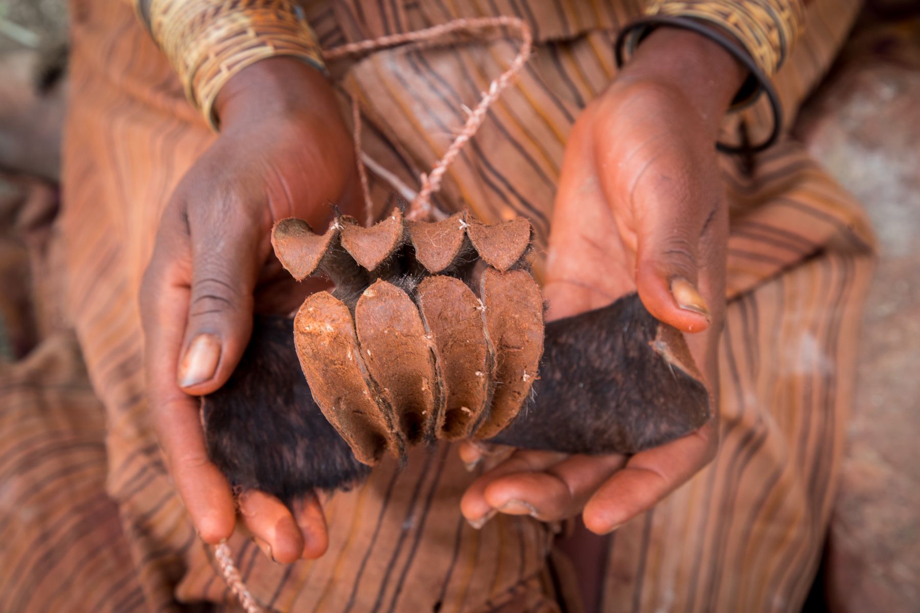 A young Himba girl holds a newly made Erembe, or the crown made of goat skin that is worn by married Himba women