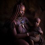 Himba woman nursing her baby on our Namibia photography tour