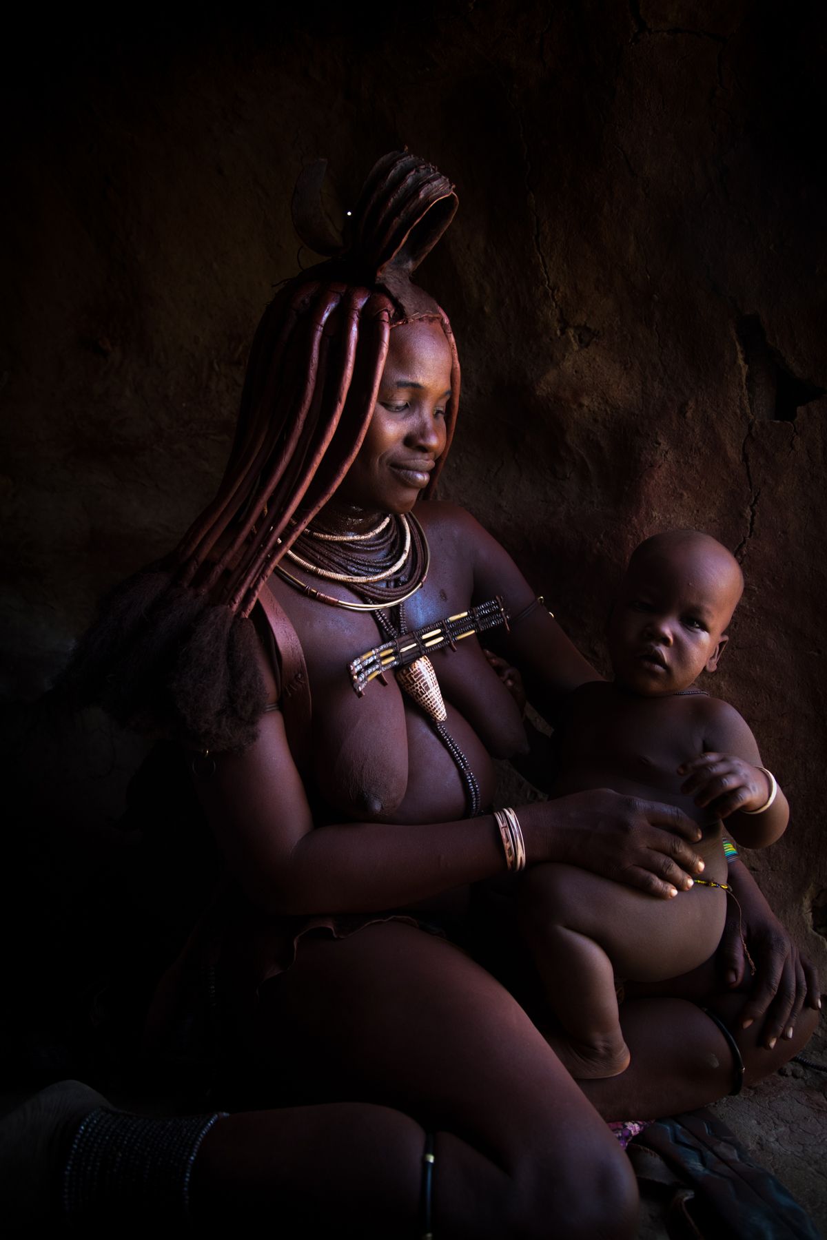 Himba woman nursing her baby on our Namibia photography tour