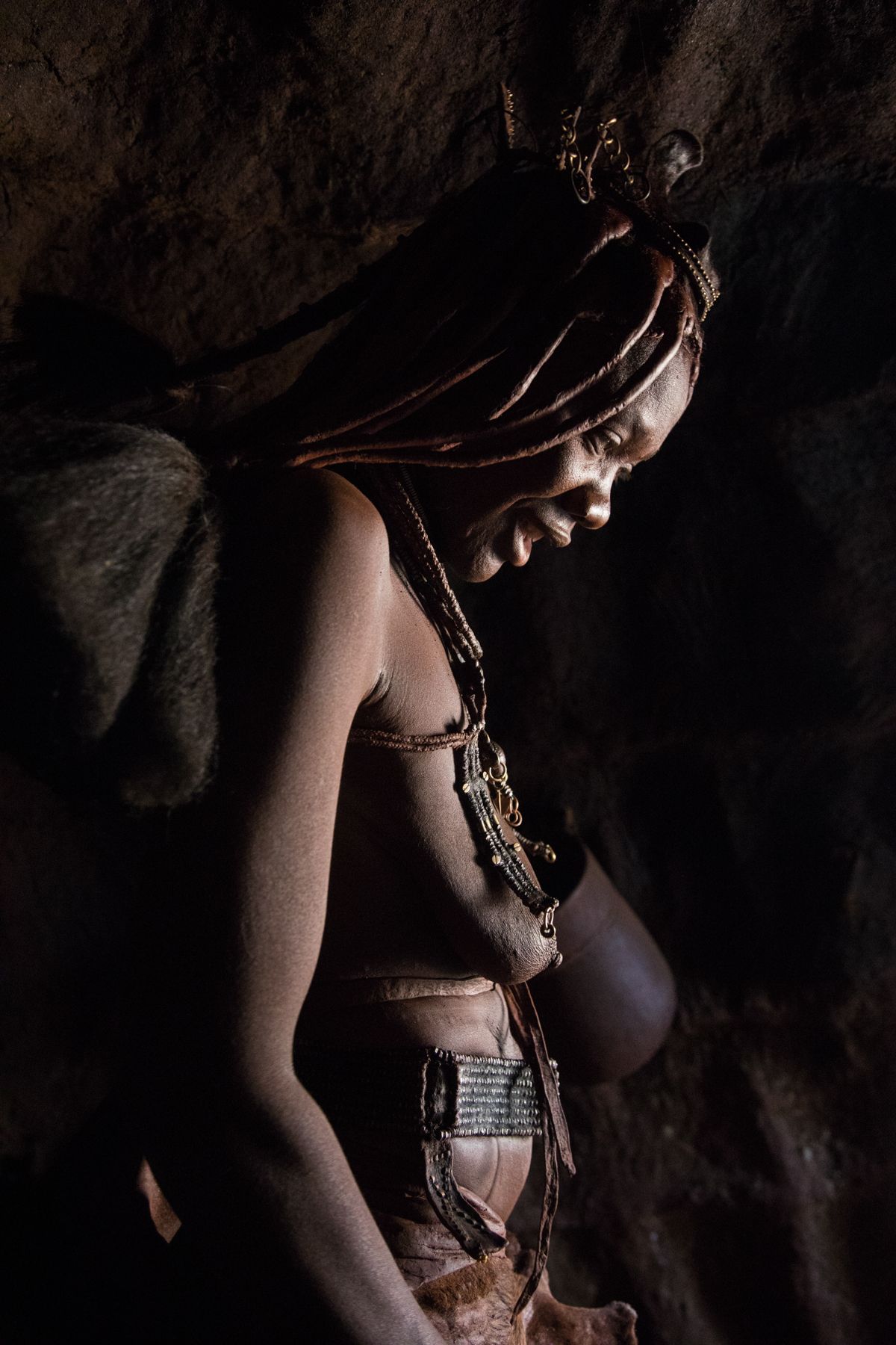 Profile of a beautiful Himba woman in her hut