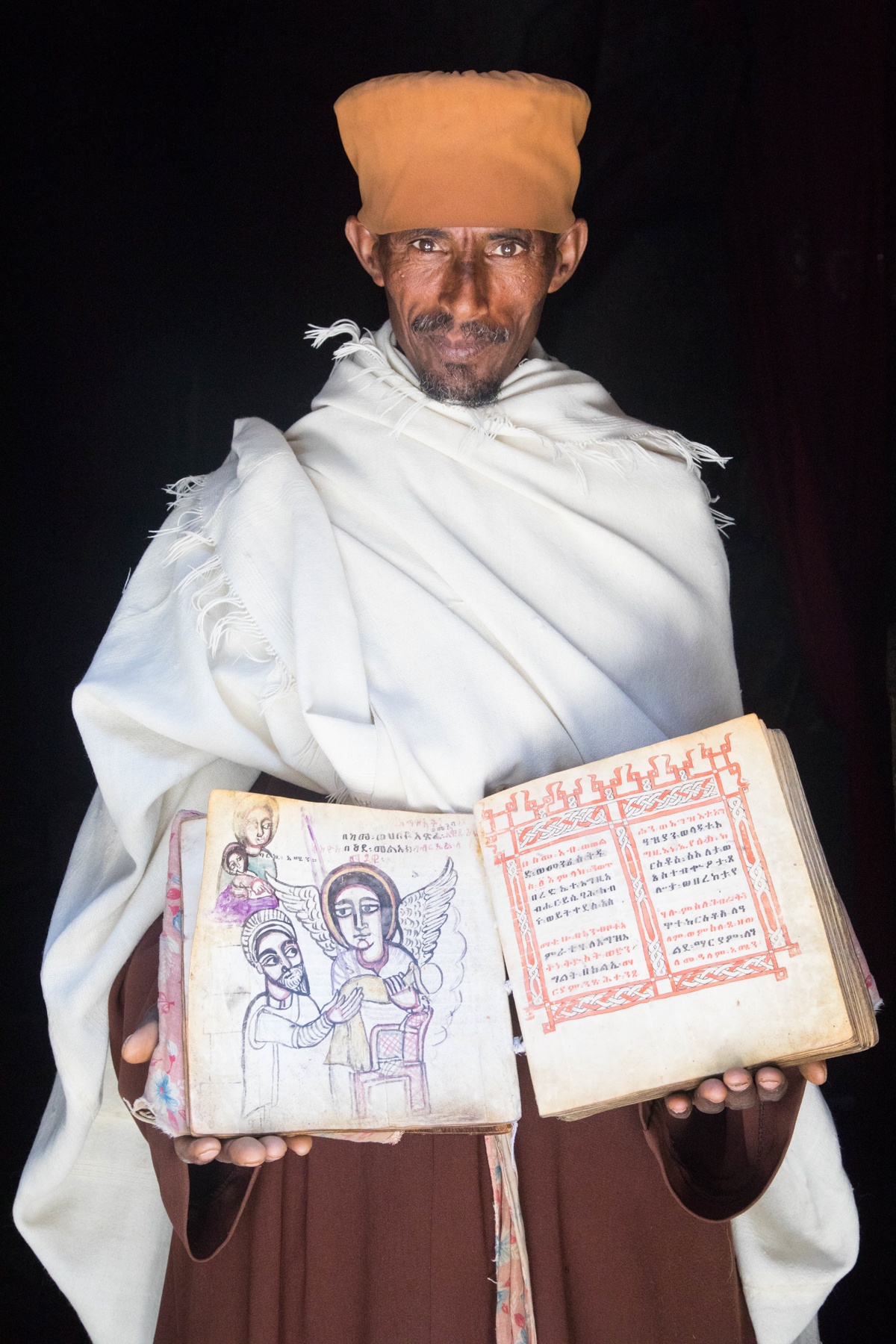 A priest at the chapel of Asheten Maryam holds one of his treasured bibles