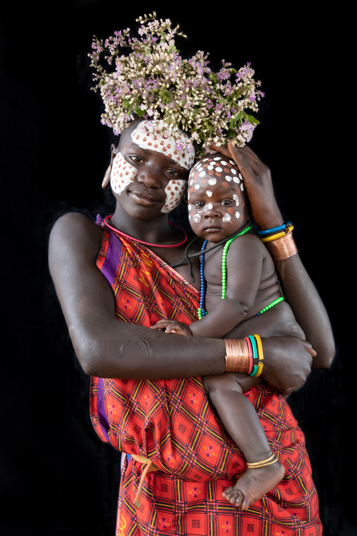 Portrait of a young Suri girl with her baby sister on the Wild Images photo tour of the Omo Valley