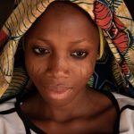 Portrait of Bassila, a beautiful Holi girl, with her facial scarification on our Benin photography tour