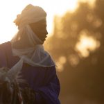 A Batonu horseman prepares to ride his horse into the sunset on our photography tour of Benin