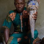 Portrait of Bruno, a voodoo chief, holding a cow's horn that is used as a judicial tool in voodoo religion