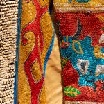 Originally from the Yoruba culture of Nigeria, the dresses of Egungun masked dancers are richly embroidered with sequins and cowrie shells