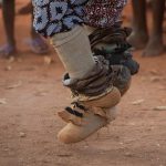 Bells adorn the legs of a Guelede dancer in eastern Benin on our Benin photography tour