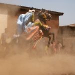 Idriss races his horse in a cloud of dust in Parakou