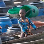 A young Tofinu boy queues to buy fresh water in Ganvie, the Venice of West Africa