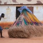 A Zangbeto twirls towards a guard at dusk