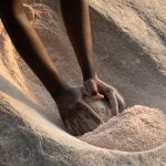 Grinding millet in a Lotuko village