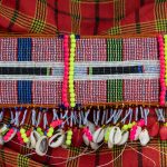 Threading the beads of traditional belts in a Laarim village