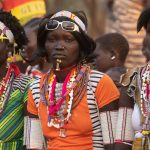 In a riot of colour, onlookers at a Laarim Nakeku dance stop to watch us taking photos on our South Sudan photo tour