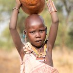 Young Laarim children are often tasked with fetching good in gourds that they carry on their heads