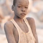 Portrait of a young Mundari boy covered in ash on our photography tour in South Sudan