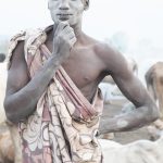 A Mundari man covers himself in ash for decoration