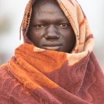 On cold mornings Mundari wrap themselves in brightly coloured blankets to stay warm