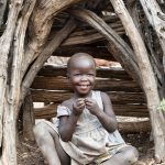 Portrait of Supaida, a young Lotuko girl in the wooded entrance to her village
