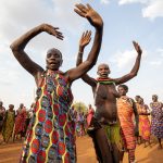 Toposa women dancing a Meriye stop to pose in the same stances as their cows