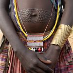 Scarification and beautiful jewellery adorn the body of a young Toposa girl