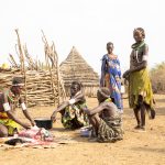 A Toposa family gathers to butcher a slaughtered goat on our photo tour to South Sudan
