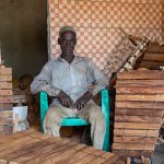 An elderly man oversees the making of balafons at the workshop of legendary balafon maker Soro Zana