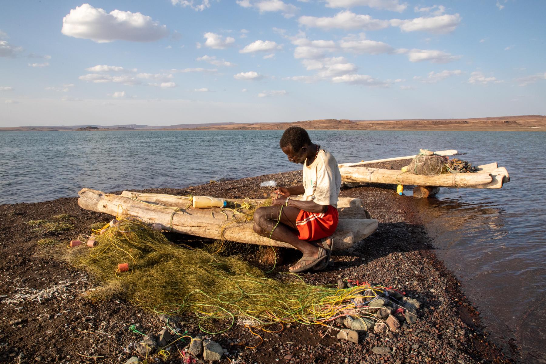 An El Molo fishermen mends his nets on our photo tour of Lake Turkana in Kenya