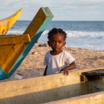 A pretty young girl plays around the pirogues of Grand Bassam