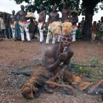 A Senufo fire master of N'Goro holds a live ember during the dance