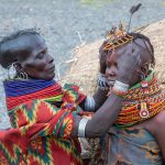 A Turkana woman prepares her grand daughter for a dance