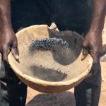 A Senufo blacksmith shakes ore before taking it to a blast furnace