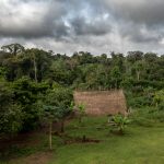 Storm clouds brew over a remote community of Waorani on our photo tour in the Amazon