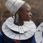 Unlike the Maasai women of Kenya, Tanzanian Maasai women adorn themselves with beautiful white disc necklaces and hats