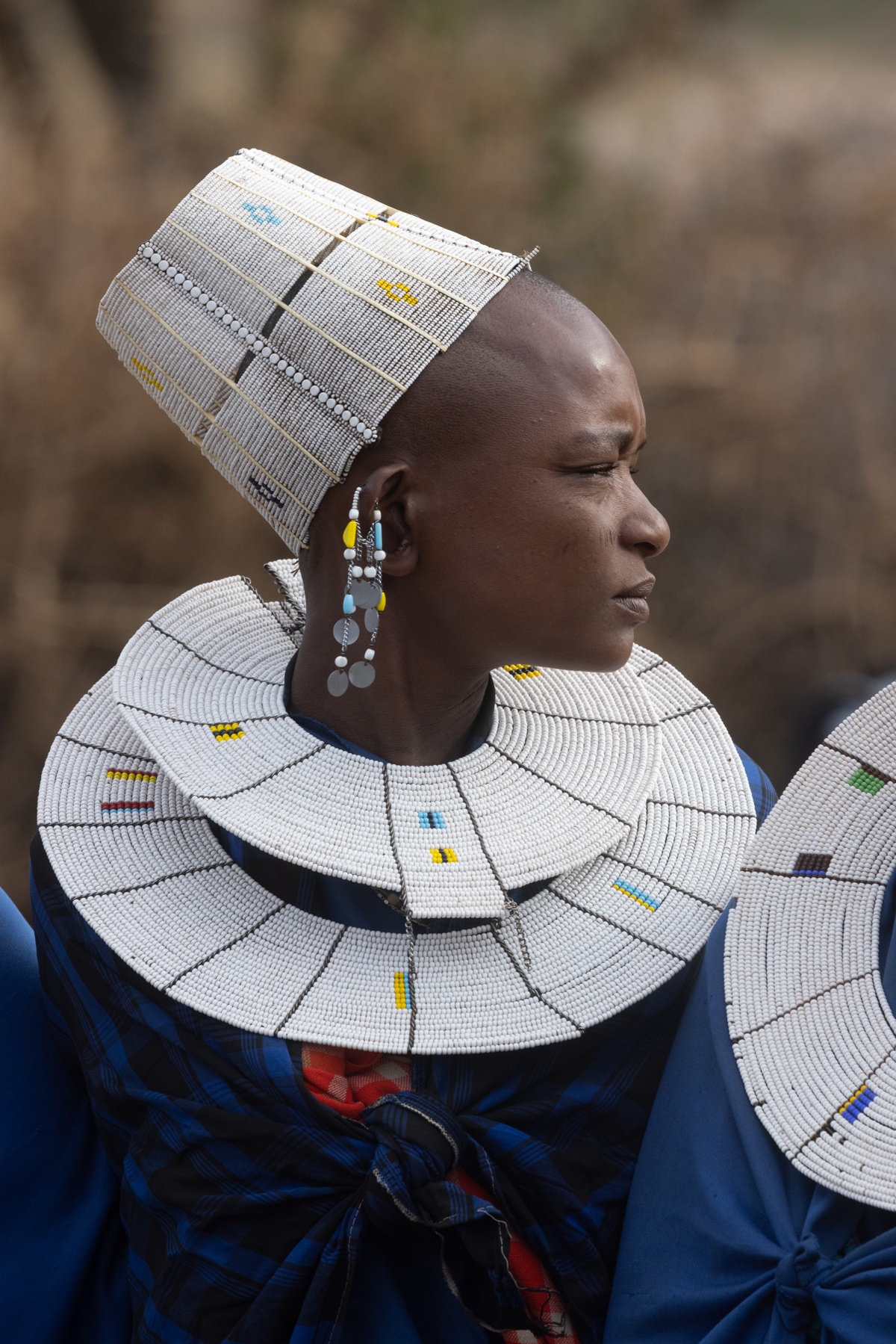 Unlike the Maasai women of Kenya, Tanzanian Maasai women adorn themselves with beautiful white disc necklaces and hats