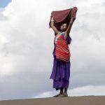 A beautiful Maasai girl embraces the sun on top of the Shifting Sand dune near Oldupai