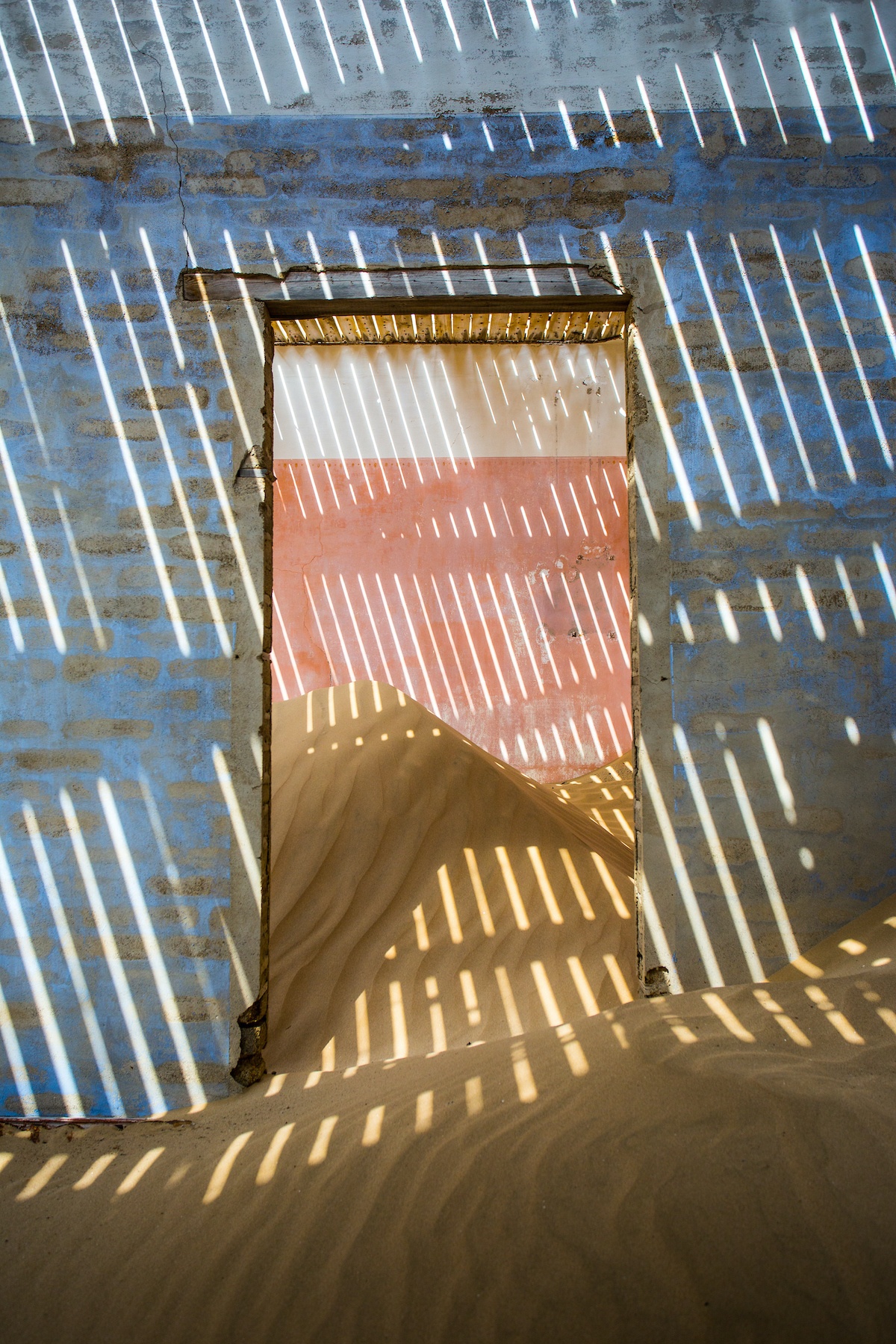 Exploring the 'slat room' in the deserted mining town of Kolmanskop during our photo tour of Namibia