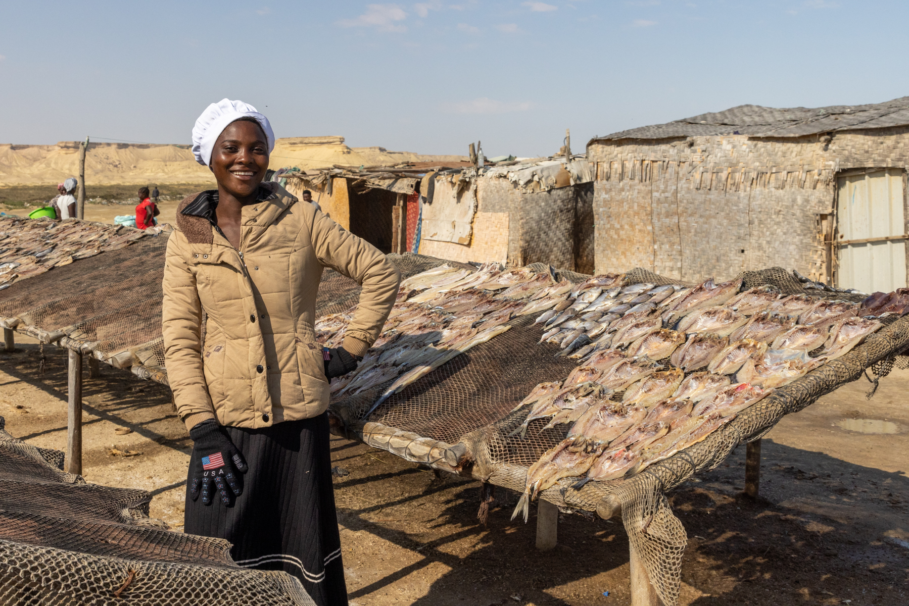 A smiling Kwepe lady shows us her fish drying racks during our tribal photography tour of Angola