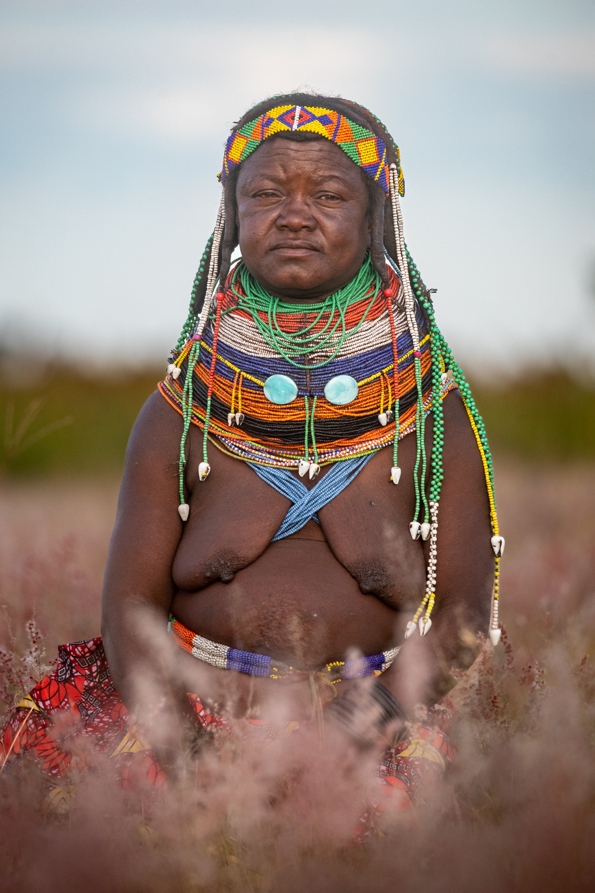 Photograph of an elderly Ovamwila woman in the grasslands on our Angola tribal photography tour