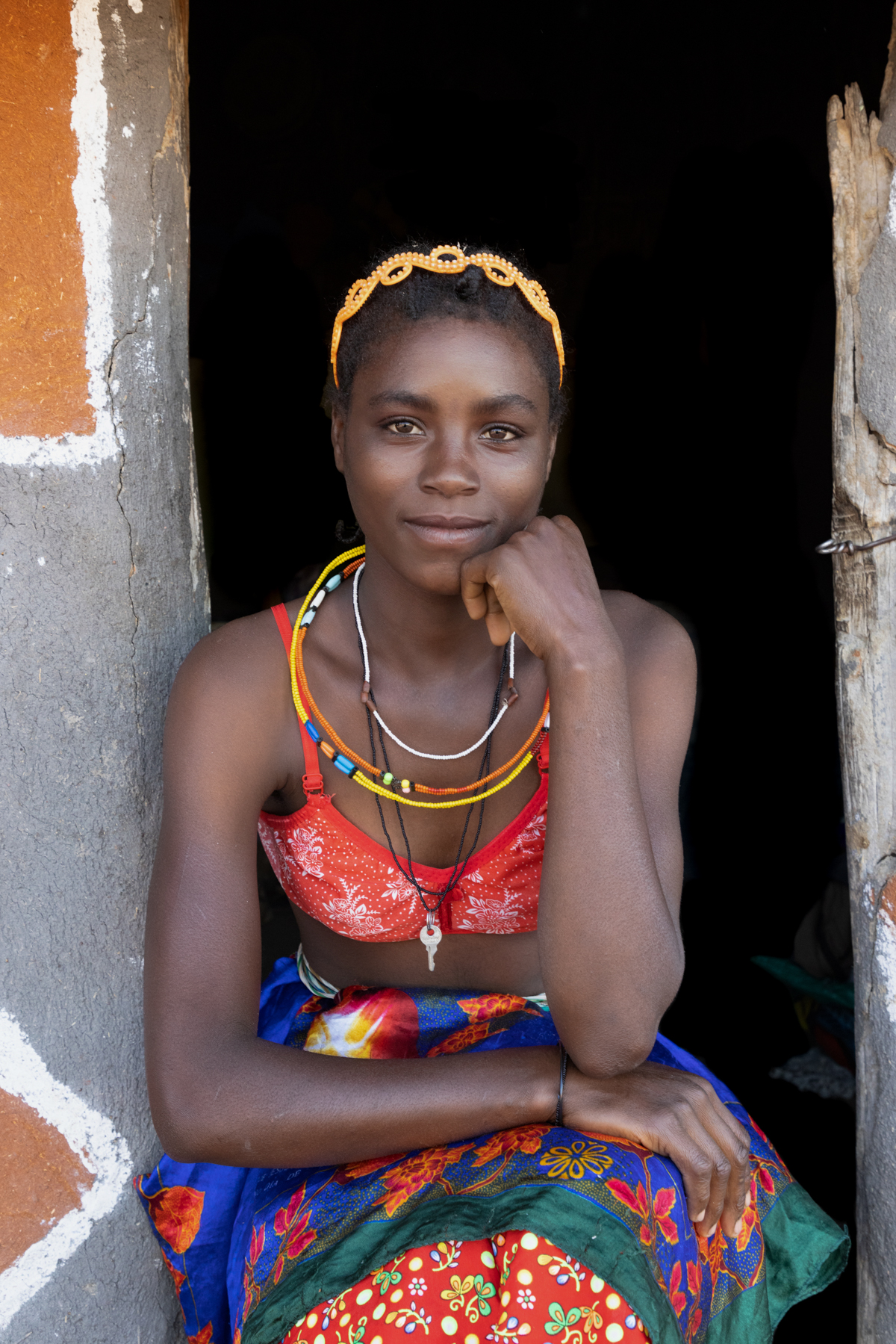 Portrait of a beautiful Ovandimba lady in the doorway of her home