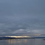 The last rays of sun crushed between the sea and the leaden sky at Flatey (image by Mike Watson)