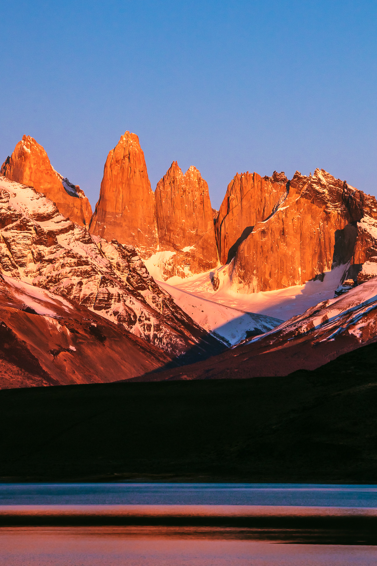 The famous ‘towers’ of the Paine Massif, Torres del Paine National Park, glow orange in the morning sunrise