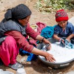 A local Zanskari woman and her granddaughter washing clothing together at Cha Village (image by Julie-Anne Davies)