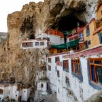 Showing the 2500 meditation cave near the top of the image and Phugtal as it was built into the surrounding limestone cliffs (image by Julie-Anne Davies)