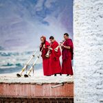 Monks playing the large Dung Chen horns at the 5:30am ‘Call to puja’ on the rooftop of Karsha Monastery, with the wide open Padum farmlands below (image by Julie-Anne Davies)