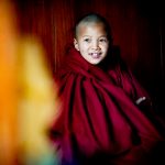 A young Phugtal monk bundled up for early morning puja (image by Julie-Anne Davies)