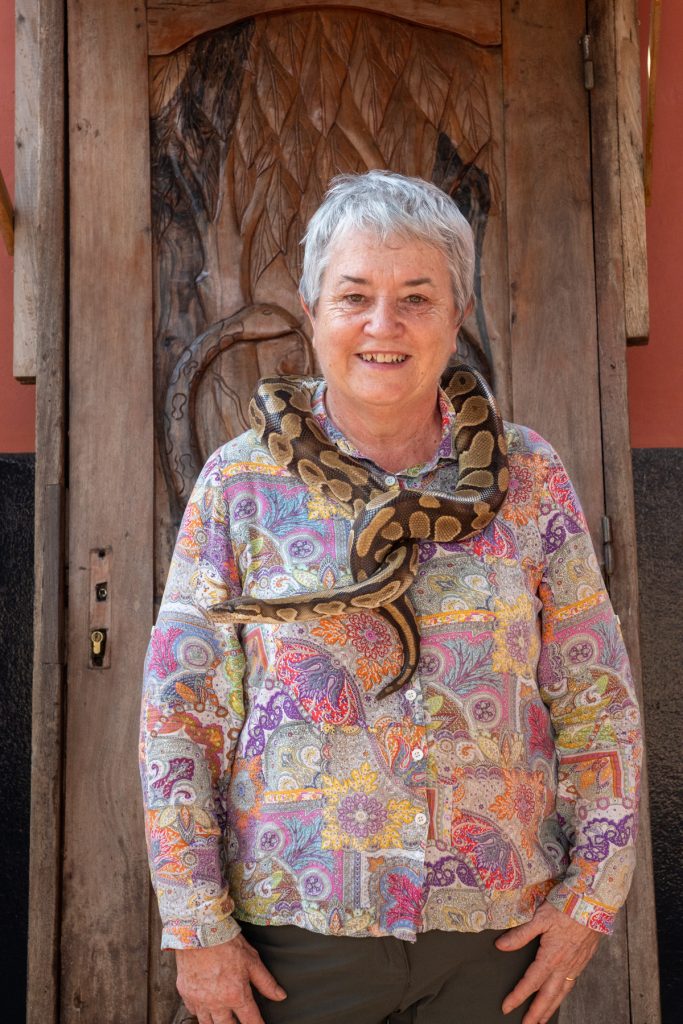 Ann braves the chance to hold one of Ouidah's pythons at the python temple (image by Inger Vandyke)