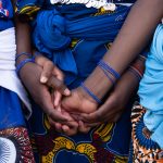 Borgu Fulanis choose the colour of royal blue as their traditional dress. Here a group of young Fulani girls hold hands in friendship against a backdrop of their pretty dresses (image by Inger Vandyke)