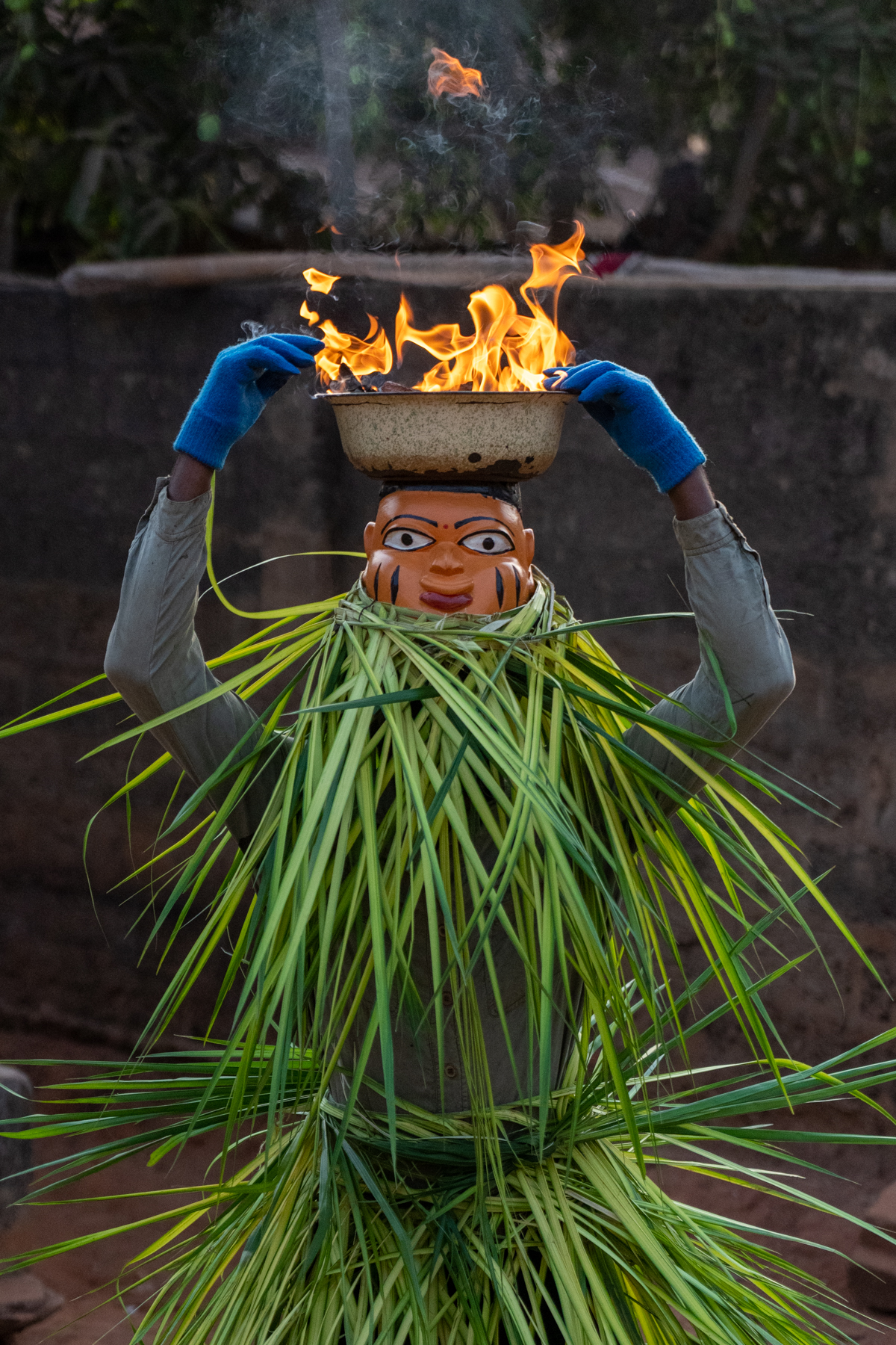 A Guèlèdè dancer reaches into his flaming bowl to grab live embers which he threw on the ground near our feet! (image by Inger Vandyke)