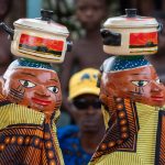 Guèlèdè dancers wearing masks depicting cooking at a private ceremony for our tour (image by Inger Vandyke)